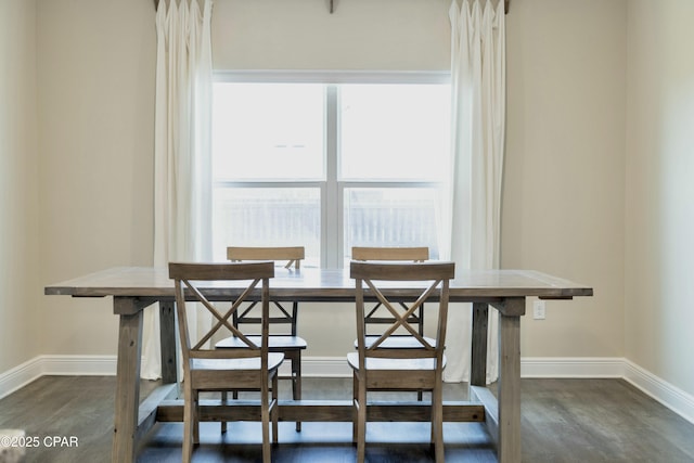dining room featuring breakfast area, baseboards, and dark wood finished floors