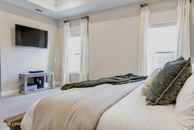 carpeted bedroom with crown molding, visible vents, and baseboards