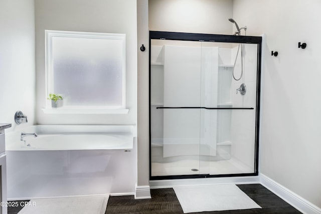 full bath with a bath, baseboards, and a shower stall