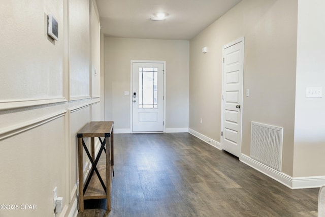 entrance foyer with baseboards, visible vents, and dark wood-type flooring