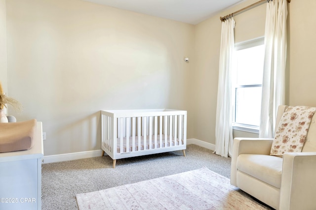 carpeted bedroom with a nursery area and baseboards