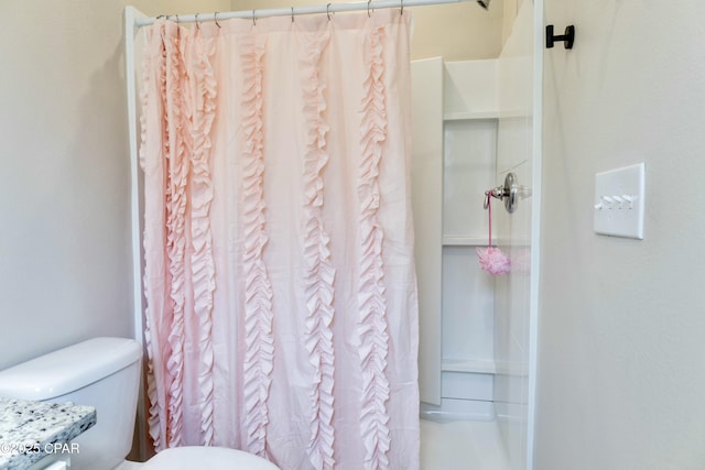 bathroom featuring toilet and a shower with curtain