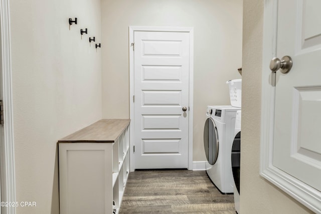 laundry room featuring washing machine and clothes dryer, laundry area, and wood finished floors