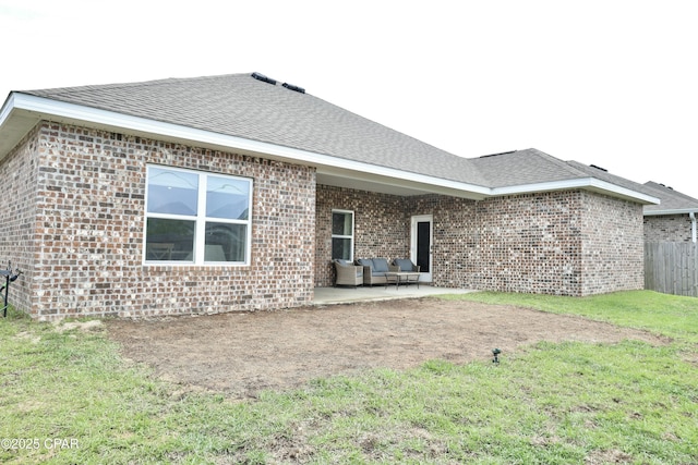 rear view of house with a lawn, a patio area, brick siding, and an outdoor living space