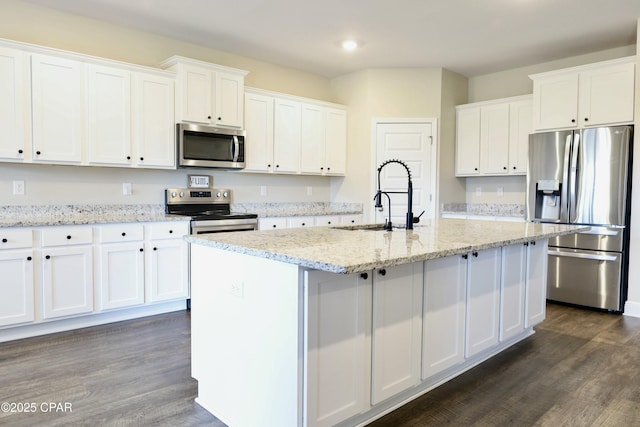 kitchen with dark wood-style flooring, white cabinets, appliances with stainless steel finishes, and a sink