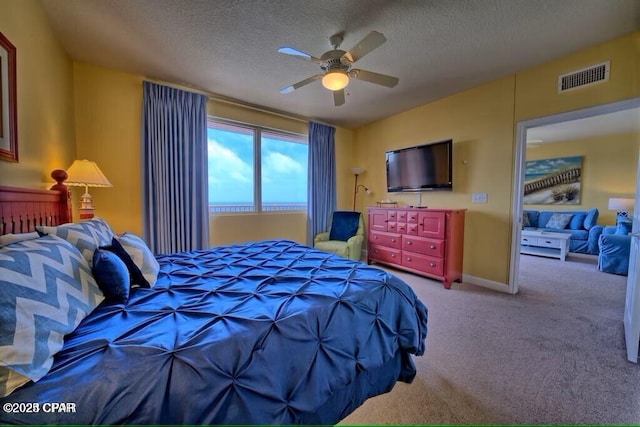 bedroom with visible vents, a ceiling fan, carpet, and a textured ceiling