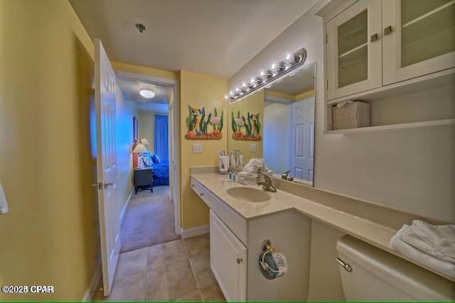 bathroom with tile patterned floors, vanity, baseboards, and toilet
