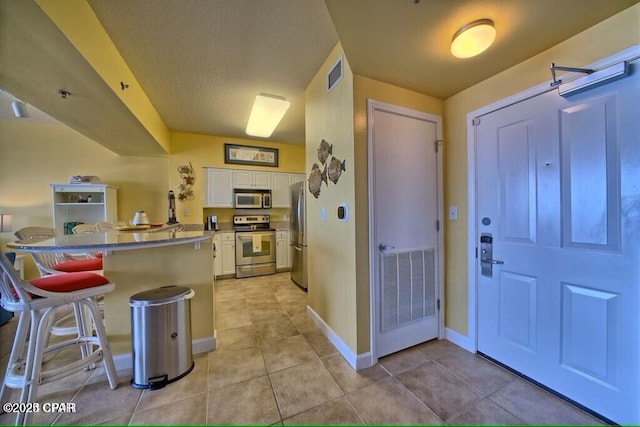 foyer featuring visible vents, baseboards, and light tile patterned floors