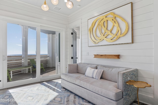 12401 Front Beach Rd, Panama City Beach, FL 32407 - living area featuring wooden walls, visible vents, ornamental molding, and wood finished floors