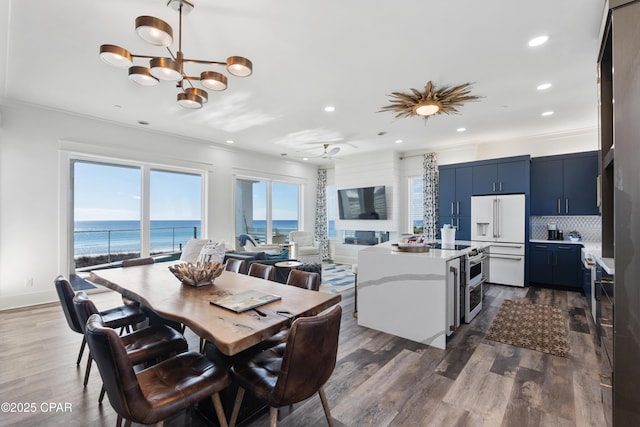 12401 Front Beach Rd, Panama City Beach, FL 32407 - dining room featuring recessed lighting, dark wood-style flooring, an inviting chandelier, and crown molding