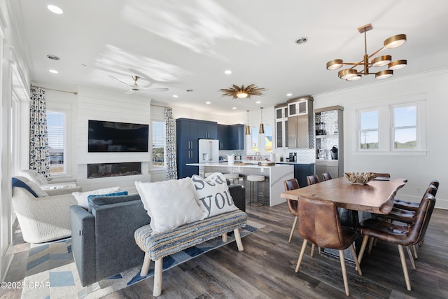 12401 Front Beach Rd, Panama City Beach, FL 32407 - dining room featuring a large fireplace, recessed lighting, crown molding, dark wood-type flooring, and ceiling fan with notable chandelier