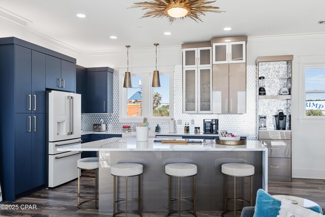 12401 Front Beach Rd, Panama City Beach, FL 32407 - kitchen with a kitchen bar, blue cabinetry, high end white refrigerator, and a healthy amount of sunlight
