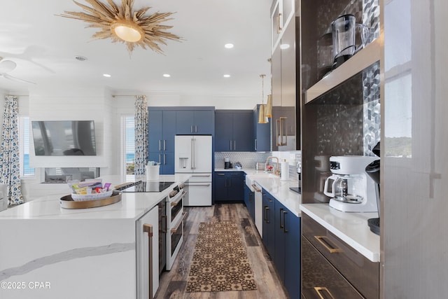 12401 Front Beach Rd, Panama City Beach, FL 32407 - kitchen featuring a center island, high quality appliances, dark wood-style floors, decorative backsplash, and blue cabinetry