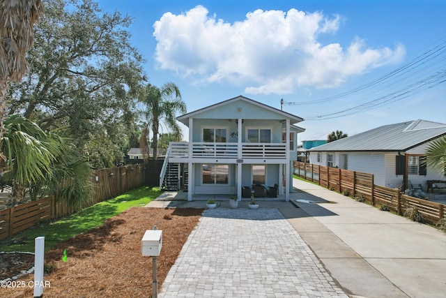 view of front of house with driveway, stairs, and a fenced backyard
