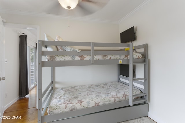 bedroom with baseboards, ornamental molding, and wood finished floors