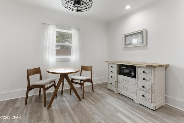 dining space with light wood-style floors, ornamental molding, baseboards, and recessed lighting