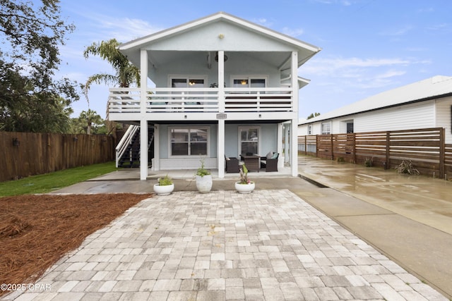 back of house with a patio area, a fenced backyard, a balcony, outdoor lounge area, and stairs
