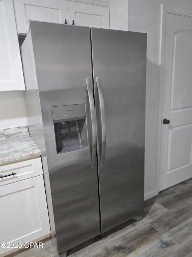 4610 Pineview Dr, Marianna, FL 32446 - kitchen featuring stainless steel fridge with ice dispenser, dark wood-style flooring, white cabinetry, and light stone countertops