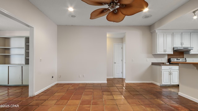 kitchen with white cabinets, a ceiling fan, baseboards, and under cabinet range hood