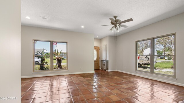 unfurnished room featuring a textured ceiling, a ceiling fan, recessed lighting, tile patterned floors, and baseboards