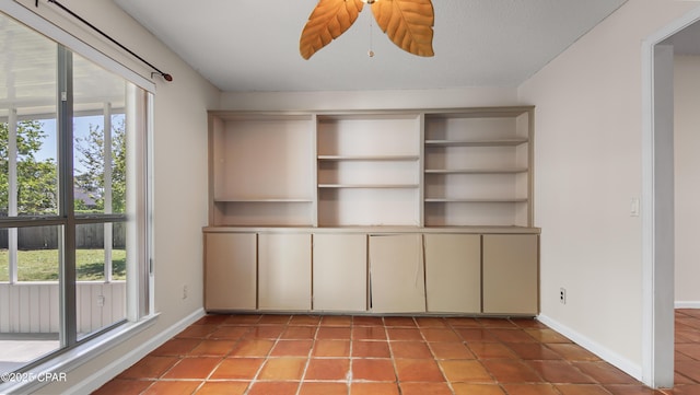 interior space featuring tile patterned floors, plenty of natural light, and baseboards