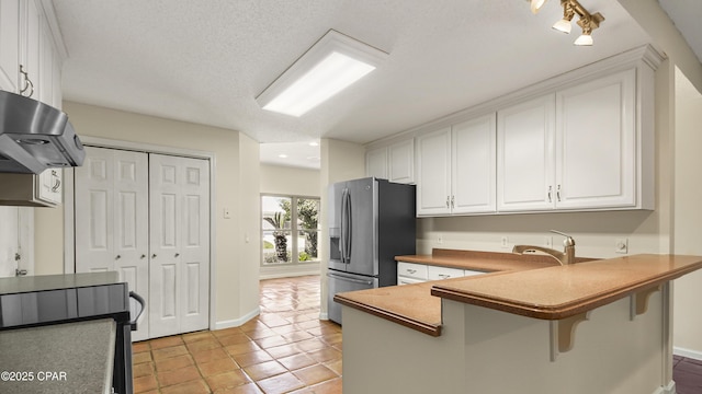 kitchen with extractor fan, white cabinetry, black / electric stove, and stainless steel fridge
