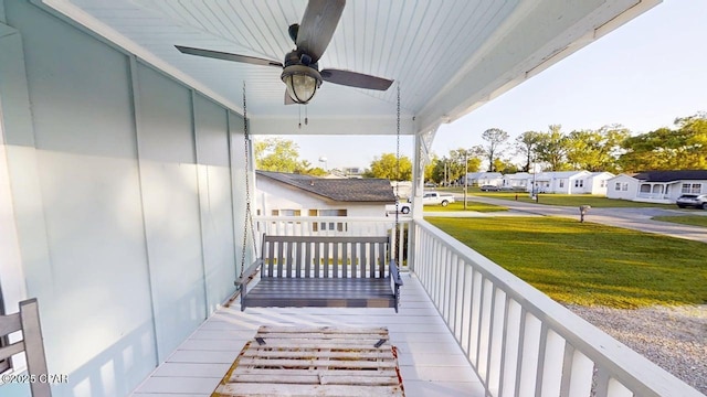 1314 Mcclelland Ave, Port St Joe, FL 32456 - wooden porch with ceiling fan, a residential view, and a yard