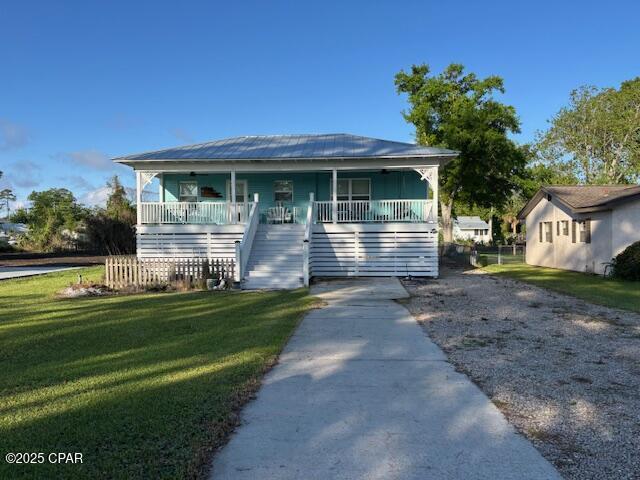 1314 Mcclelland Ave, Port St Joe, FL 32456 - view of front of house featuring stairs, a porch, and a front yard