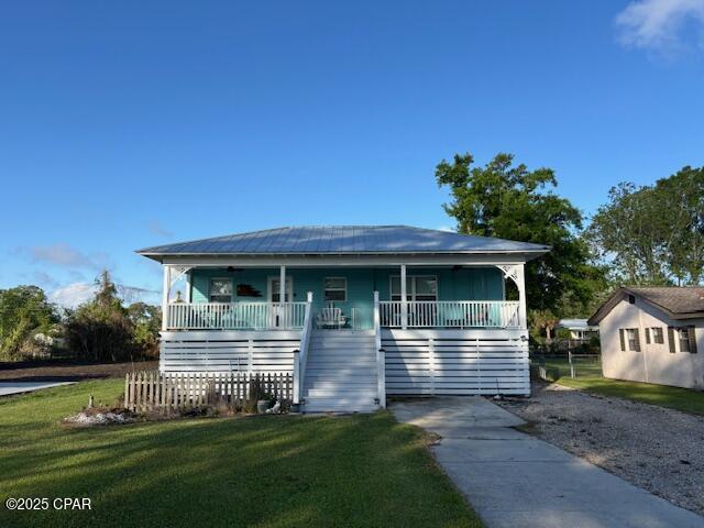 1314 Mcclelland Ave, Port St Joe, FL 32456 - view of front facade featuring stairway, covered porch, and a front yard