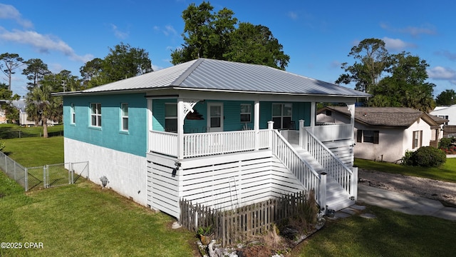 1314 Mcclelland Ave, Port St Joe, FL 32456 - view of front facade with covered porch, stairway, a gate, and metal roof