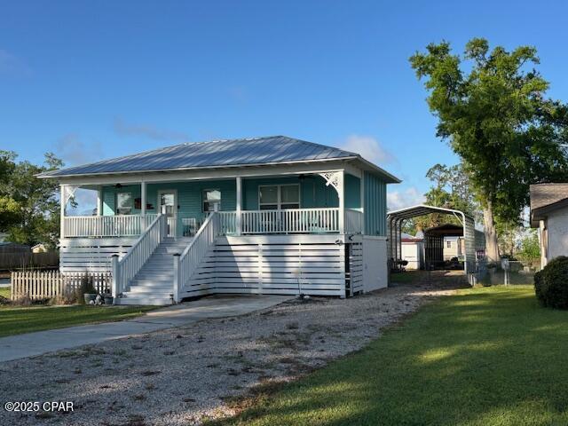 1314 Mcclelland Ave, Port St Joe, FL 32456 - view of front of house with stairway, a carport, a porch, and a front yard