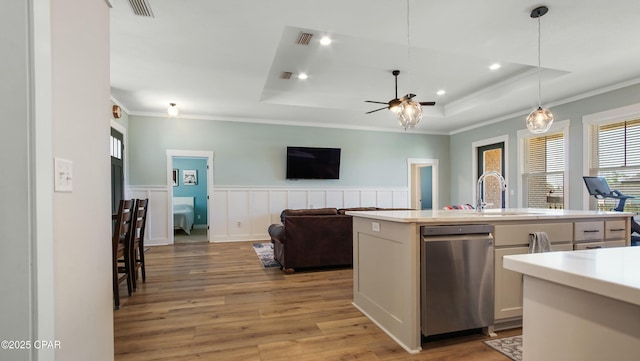 kitchen with a tray ceiling, light wood finished floors, light countertops, and a ceiling fan