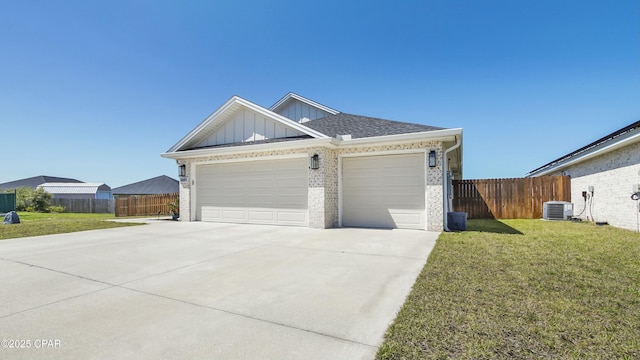 view of front of home with board and batten siding, a front yard, fence, an attached garage, and concrete driveway