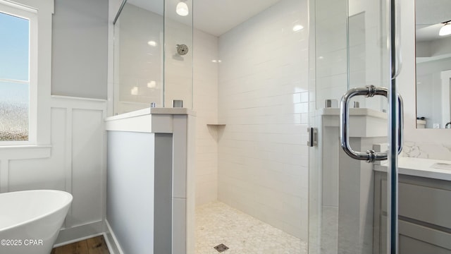 full bathroom featuring a freestanding bath, vanity, and a stall shower