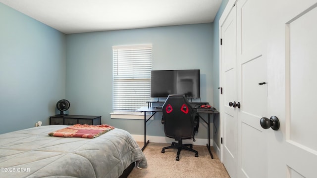 bedroom featuring carpet, baseboards, an office area, and a closet