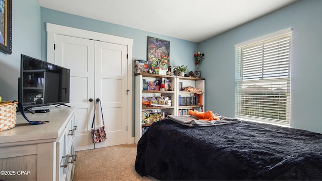 bedroom with light colored carpet and a closet