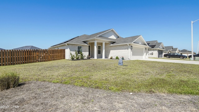 view of front of property featuring a garage, brick siding, fence, and a front lawn