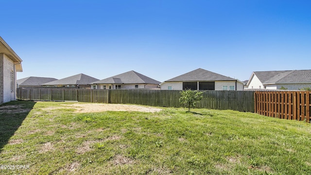 view of yard featuring a fenced backyard and a residential view