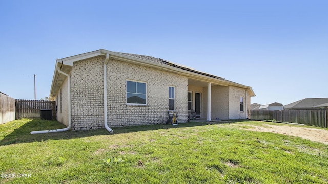 back of house with central AC and brick siding