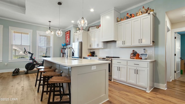 kitchen with stainless steel electric range oven, a sink, light countertops, a kitchen breakfast bar, and light wood-style floors