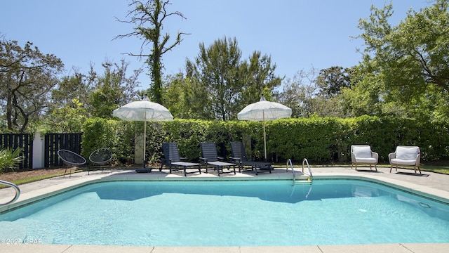 view of swimming pool featuring fence, a fenced in pool, and a patio area
