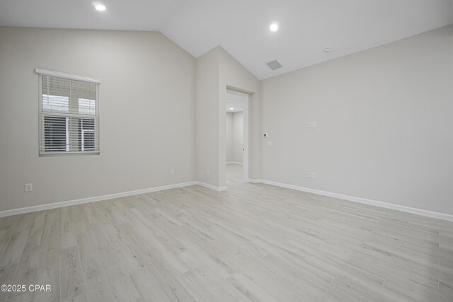 spare room featuring recessed lighting, light wood finished floors, baseboards, and lofted ceiling