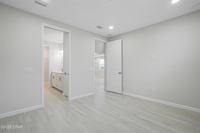 unfurnished bedroom with visible vents, light wood-style flooring, recessed lighting, and baseboards