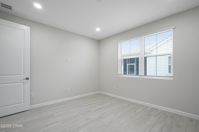 unfurnished room with light wood-style flooring, visible vents, and baseboards