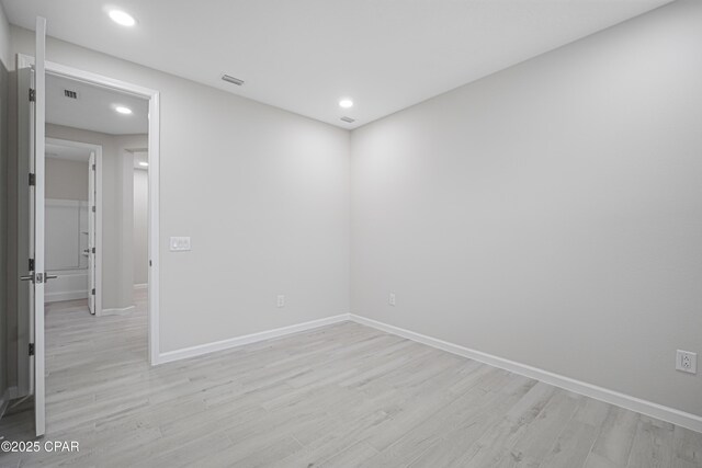 spare room with light wood finished floors, baseboards, visible vents, and recessed lighting