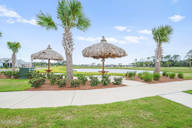 view of property's community with a water view, a gazebo, and a lawn