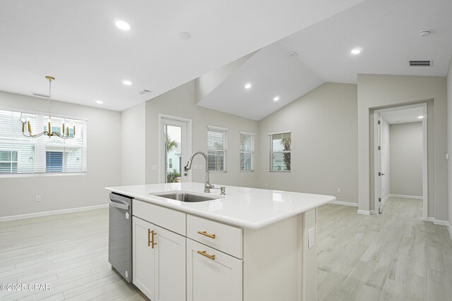 kitchen with light countertops, a sink, vaulted ceiling, and light wood-style flooring