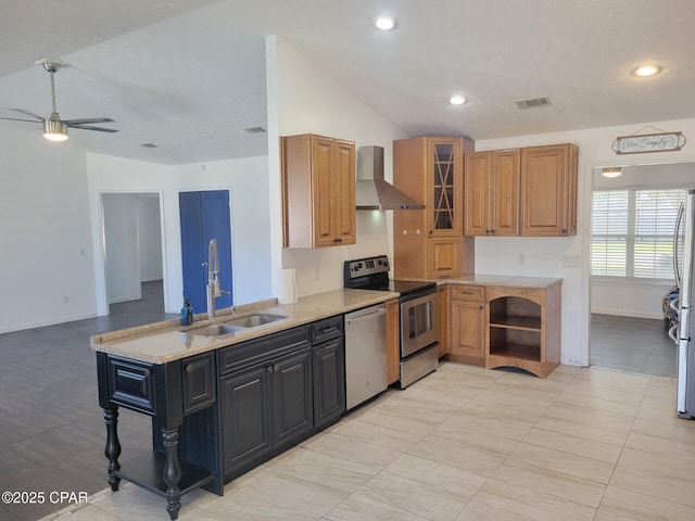 kitchen featuring visible vents, a sink, wall chimney range hood, stainless steel appliances, and lofted ceiling