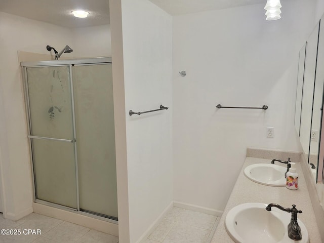 bathroom featuring a stall shower, a sink, and tile patterned floors