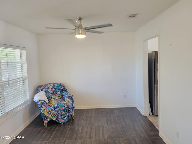 living area featuring visible vents, baseboards, a ceiling fan, and wood finished floors